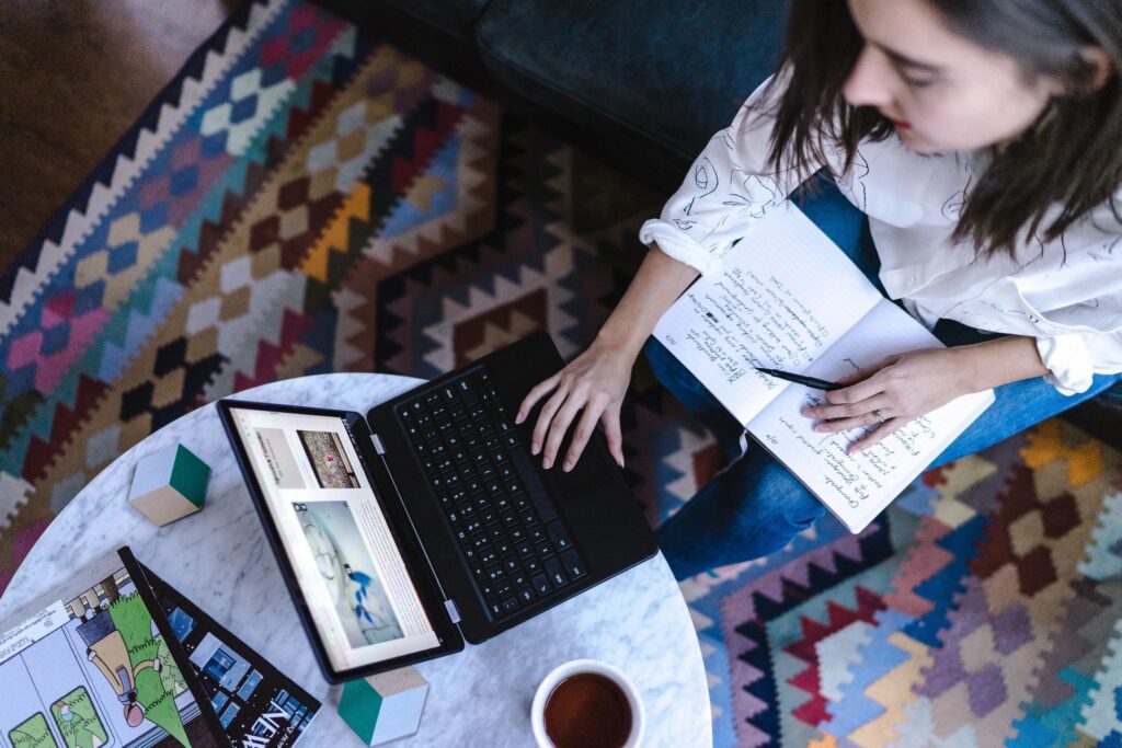 A woman sitting on the floor with her laptop.