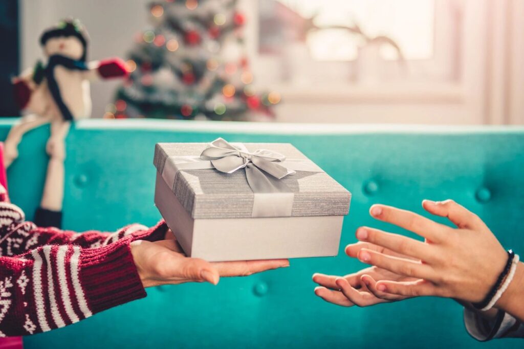 A person is giving someone a gift box