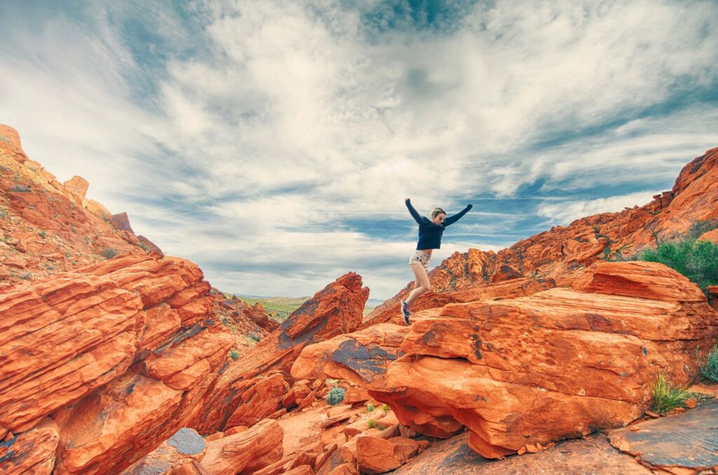 A person jumping in the air on top of rocks.