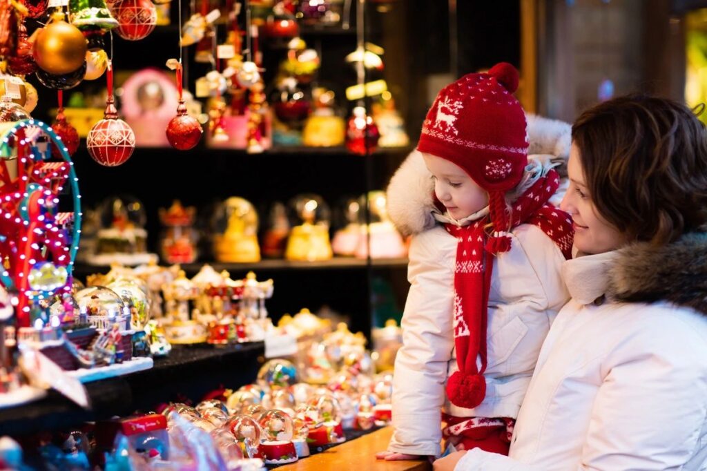 A woman and child looking at christmas decorations.